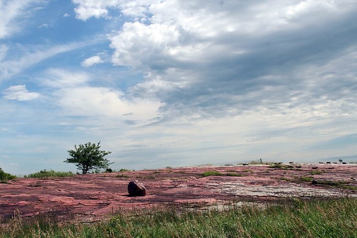 Jeffers Petroglyphs western Minnesota red rocks blue sky clouds and prairie grass