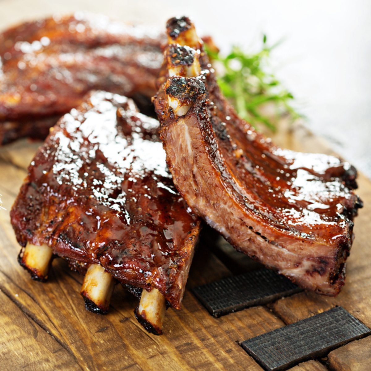 Grilled and smoked ribs with barbeque sauce on a carving board
