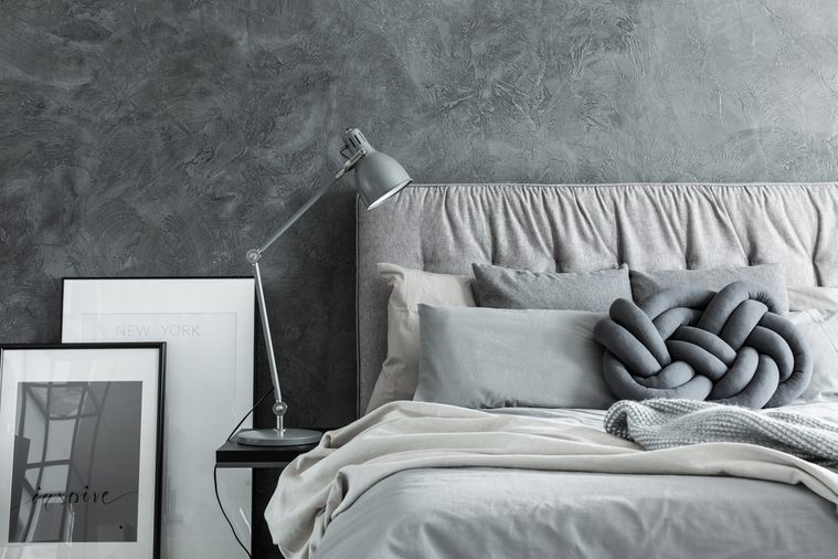 Close-up, side view of cozy modern bedroom with gray headboard