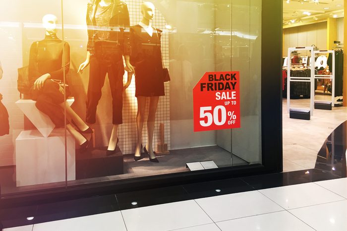 Window display with red sale board for Black Friday shopping. Vintage filter effect.
