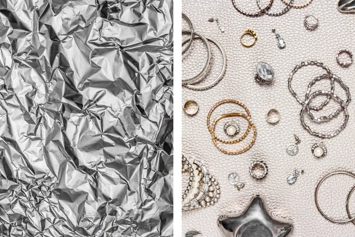 Aluminum foil texture next to variety of silver and gold jewelry