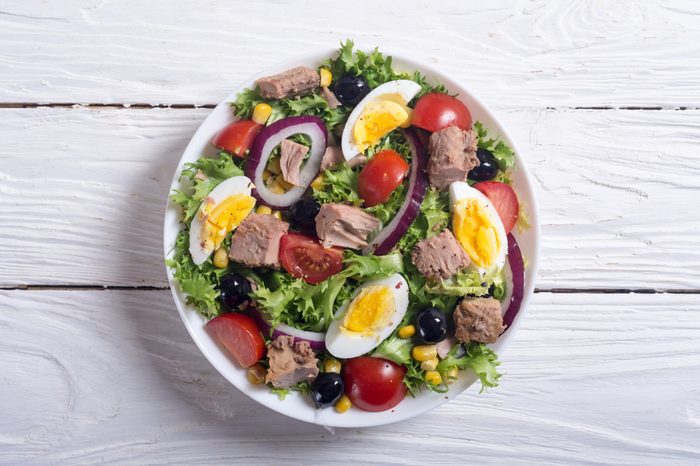 Tuna salad with tomatoes , olives , eggs and onion .