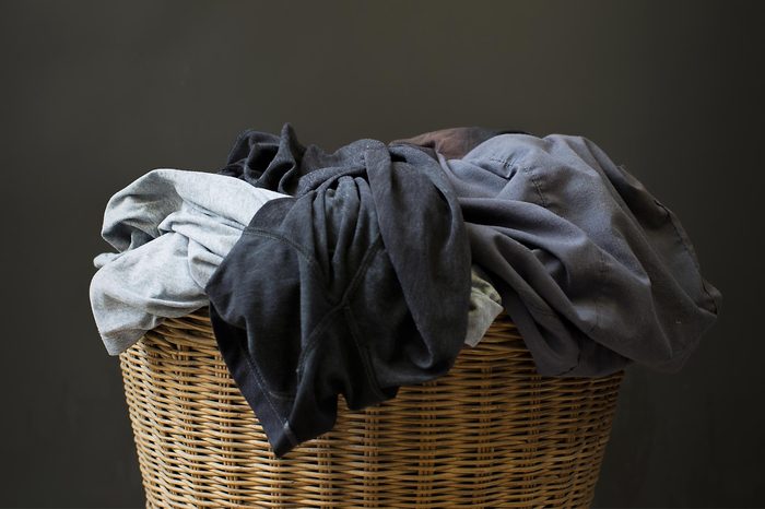 Stack clothes in a basket with a gray background.