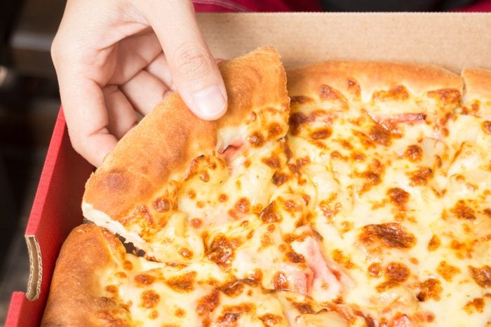 Hand on extra cheese pizza pan, stock photo