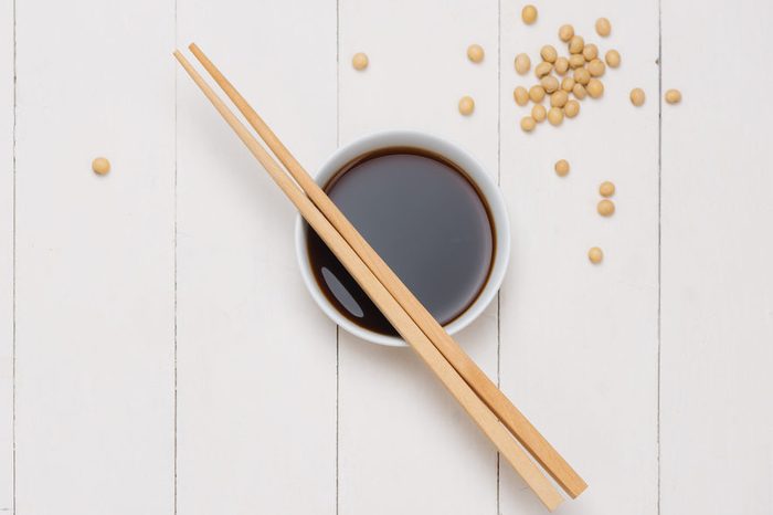 Soy sauce and soy bean with chopsticks on wooden table