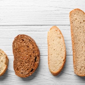 Slices on different fresh yummy bread on wooden background