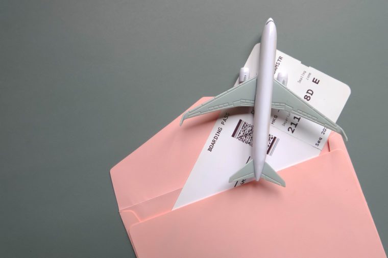 Boarding pass in gift pouch with toy airplane.