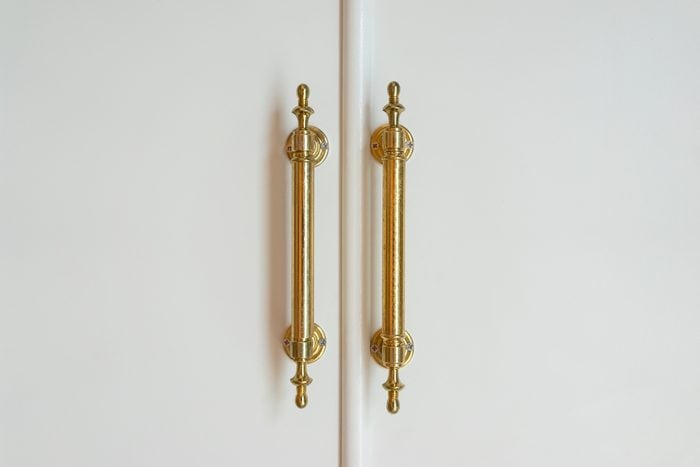 Brass handles with white doors
