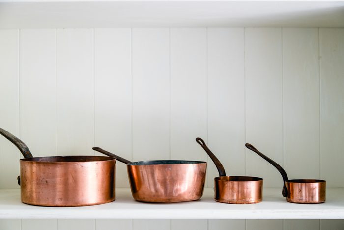 Copper kitchen saucepans standing at the counter