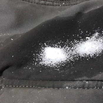 Powder sugar poured on oil stain on fabric.
