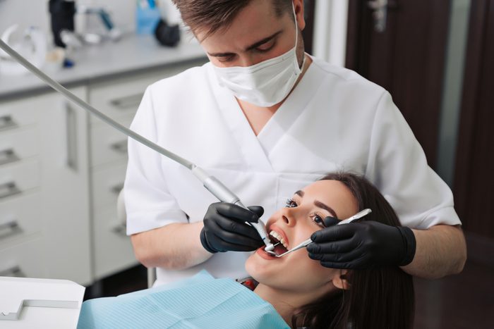 Mature male dentist working with his woman patient visiting dentist having dental checkup at the clinic dentistry occupation treatment medical industry healthcare people insurance