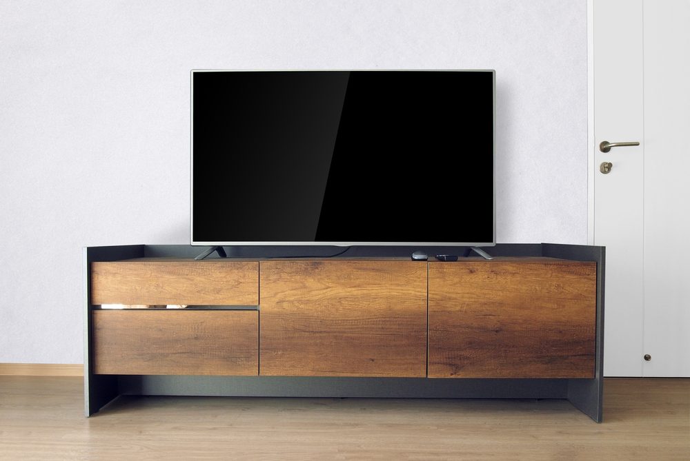 Led TV on TV stand in empty room with white concrete wall. decorate in loft style.