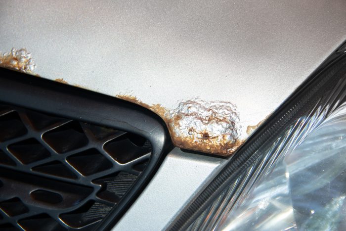 Rust on the bonnet of a silver car with black radiator grille
