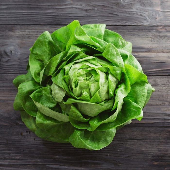 Single lettuce head over rustic wooden background