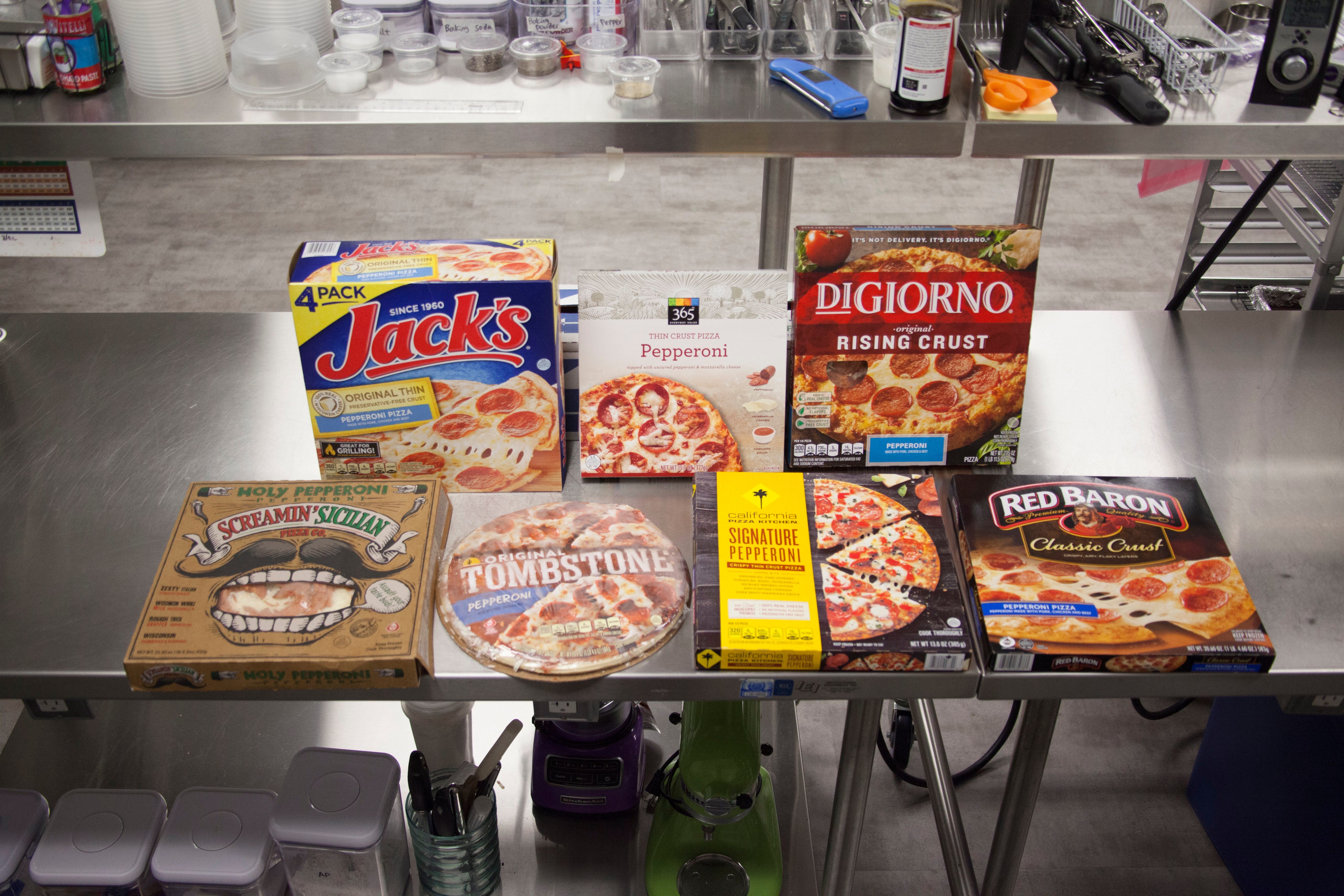 Line-up of frozen pizzas on a metal table