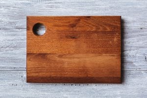 Cutting board on the wooden background. Toned photo.