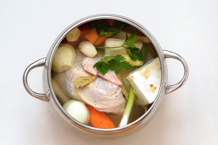Chicken soup in the pot - soup with vegetables. Carrots, celery, parsley, onion, garlic