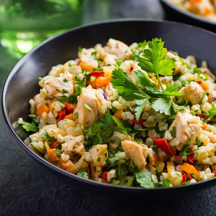 warm barley salad with chicken and vegetables, selective focus