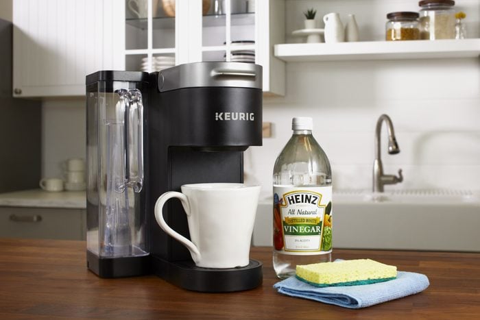 Keurig Coffee Maker And Cleaning Supplies On Kitchen Counter