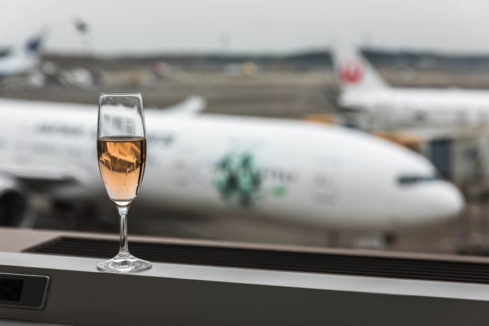 Narita airport, Tokyo, Japan, April 2018 - At airport lounge with a glass of champagne overlooking the runway.