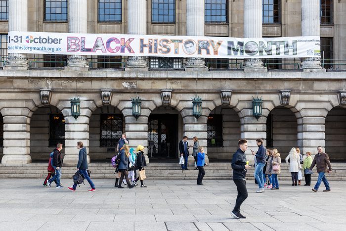 NOTTINGHAM, ENGLAND - OCTOBER 22: Various people walk past. Black History Month banner on front of Nottingham City Council House. In Nottingham, England. On 22nd October 2016.