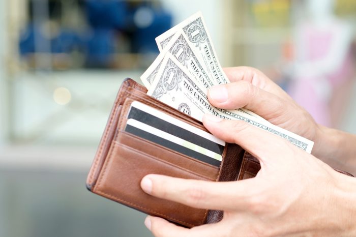 Hand of men use money from wallets. Pay the dollar Financial concepts and expenditures,