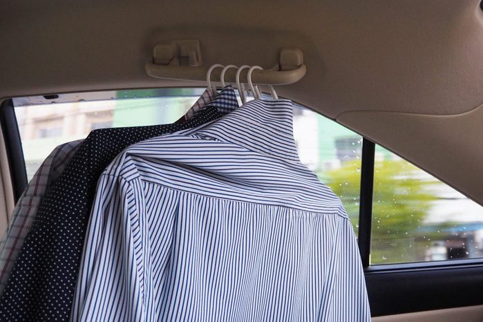 Many shirts hang in the car.