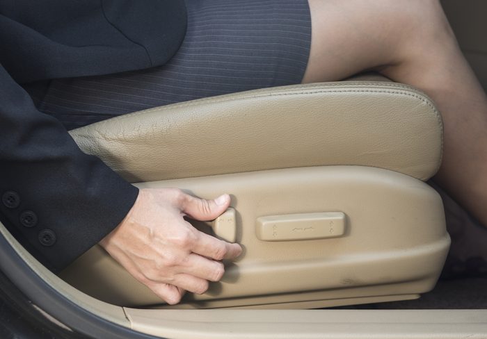 Businesswoman adjusts power seats, seat in the car