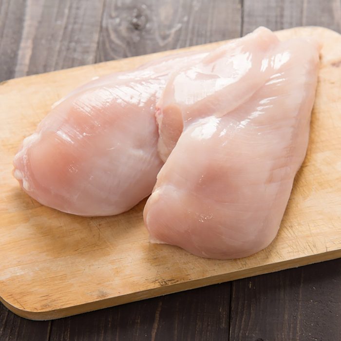 Raw chicken breast fillets on wooden background
