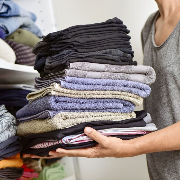 closeup of a young man carrying a pile of different folded clothes; Shutterstock ID 331641839; Job (TFH, TOH, RD, BNB, CWM, CM): Taste of Home