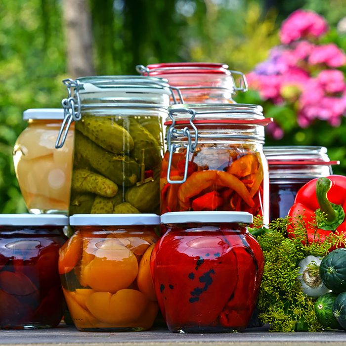 Jars of pickled vegetables and fruits in the garden.