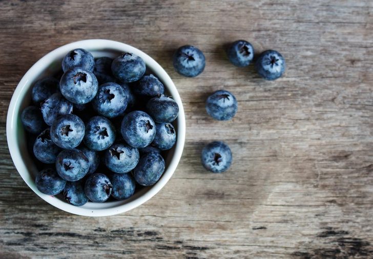 Blueberries in a white bowl on a wooden table