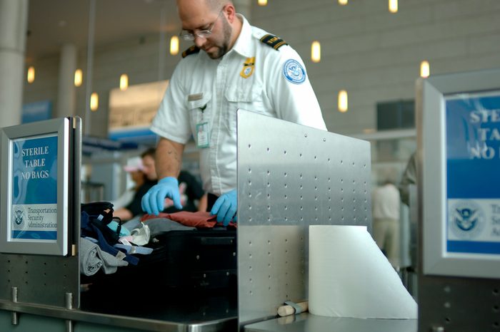 A TSA agent searches luggage at an airport. (12MP camera, NO model release, editorial only)
