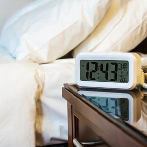 alarm clock on the bedside table in a hotel room