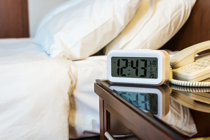 alarm clock on the bedside table in a hotel room