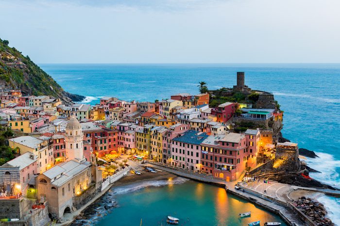 view of famous travel landmark destination Vernazza, small mediterranean old sea town with harbour coast and castle,Cinque terre National Park, Liguria, Italy. Summer early morning with street lights