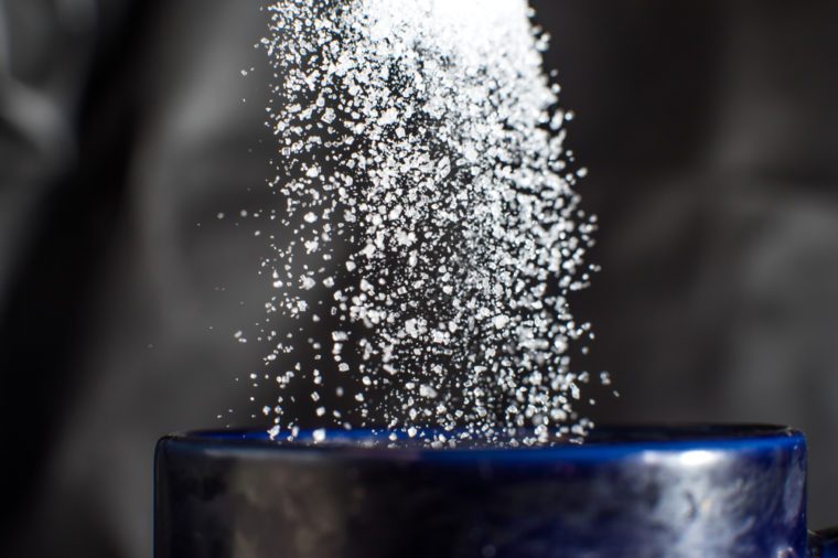 Sugar pouring down into blue cup
