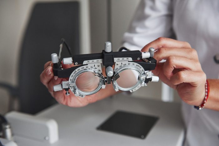 Detailed close up photo. Female hands holding the optical device for eye testing.