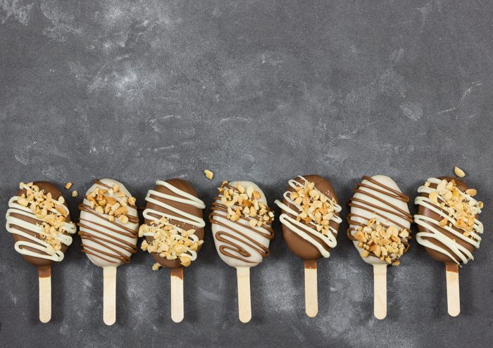 Cake pops in chocolate glaze in form of ice cream on gray stone background