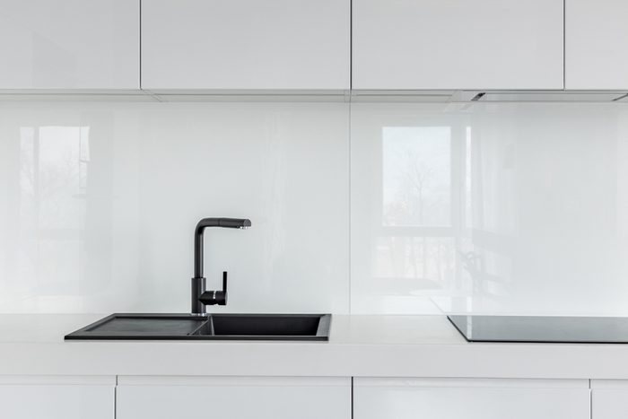 High gloss cabinets, countertop and black composite kitchen sink 