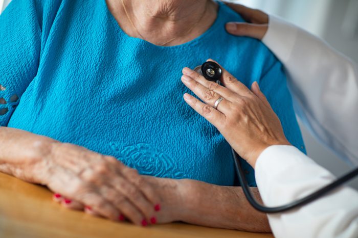 Female Doctor Checking The Heart With Stethoscope of Senior Adult Woman.
