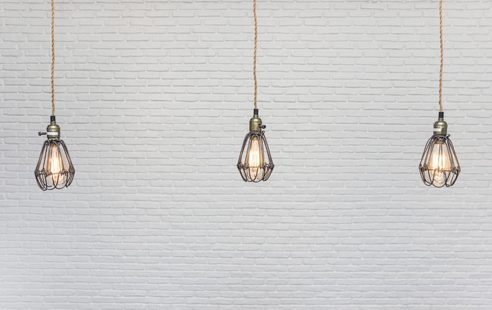 vintage lamps hanging from the ceiling with white brick wall