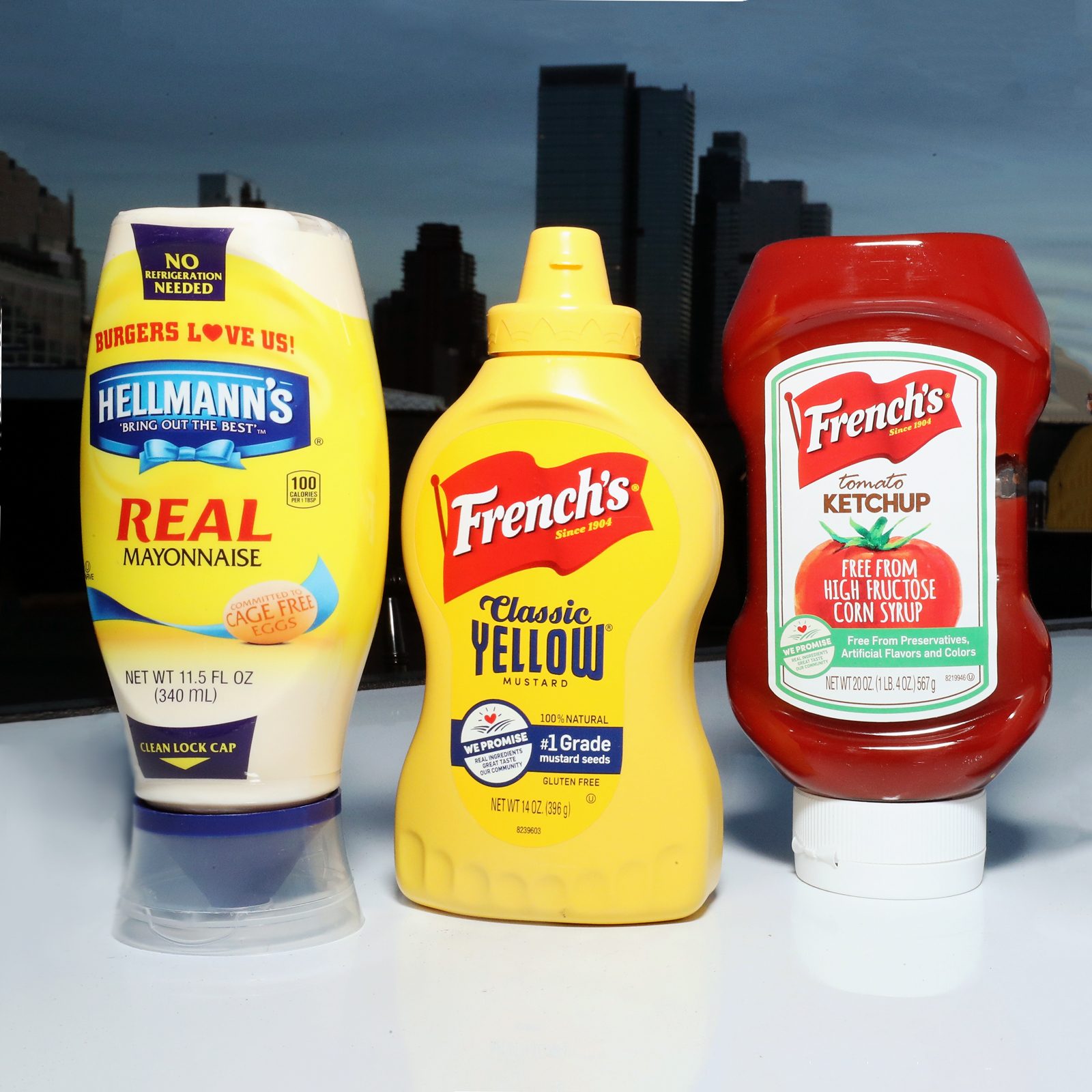 Hellman's mayonnaise, French's mustard and French's ketchup bottles on a table