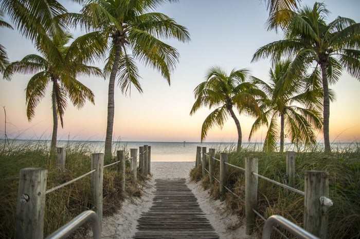 Key West Florida - Famous passage to the beach with palms, sunset and view on the ocean.