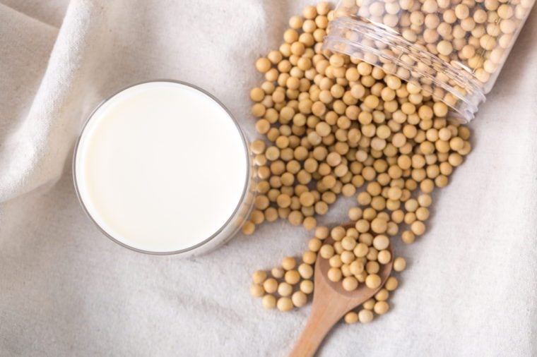 A cup of soy milk and bottled soybeans on the table, overhead shot