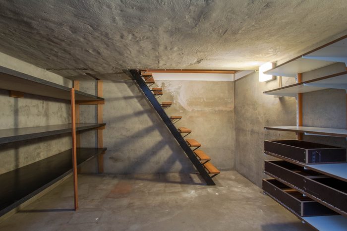 empty basement in abandoned old industrial building with little light and a wooden stairs