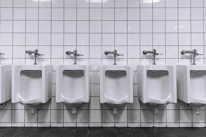Clean male toilet row of urinals in a public restroom black and white