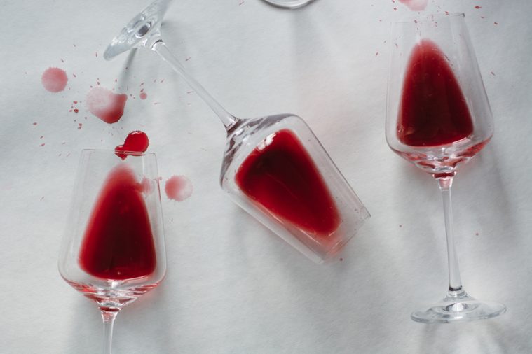 Glasses of spilled red wine on white background, copy space. Wine degustation concept