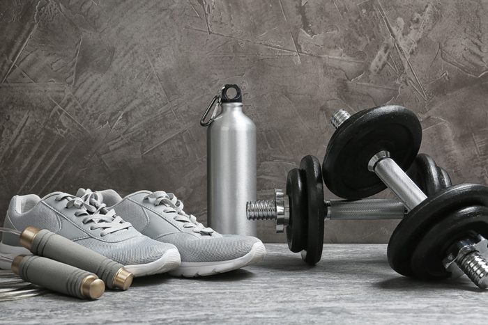 Composition with dumbbells and fitness accessories on floor