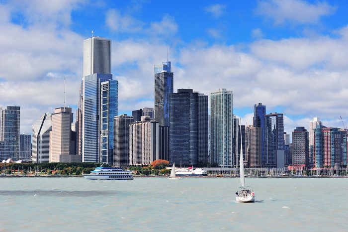 Chicago city urban skyline with skyscrapers over Lake Michigan with cloudy blue sky.